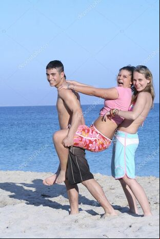 Kids goofing on beach on summer vacation or spring, break -